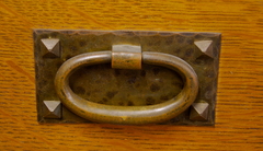 Detail early style hand-hammered copper drawer pull with pyramidal screws in original patina. 